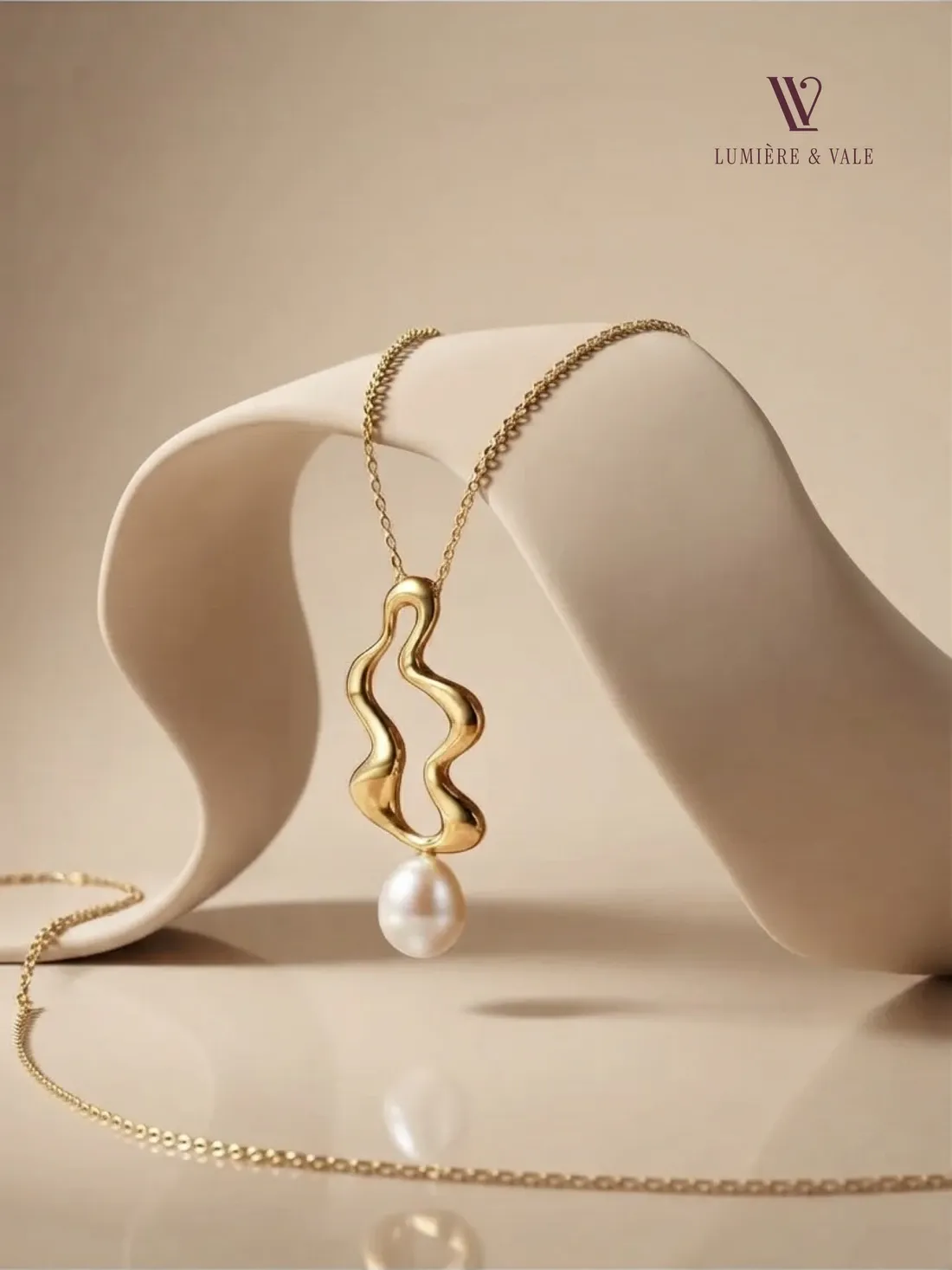 Sculpted gold pendant with a baroque pearl on an ivory drape