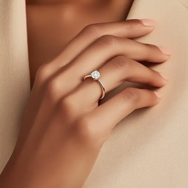 Hand resting on an ivory knit, wearing the Vesper solitaire ring