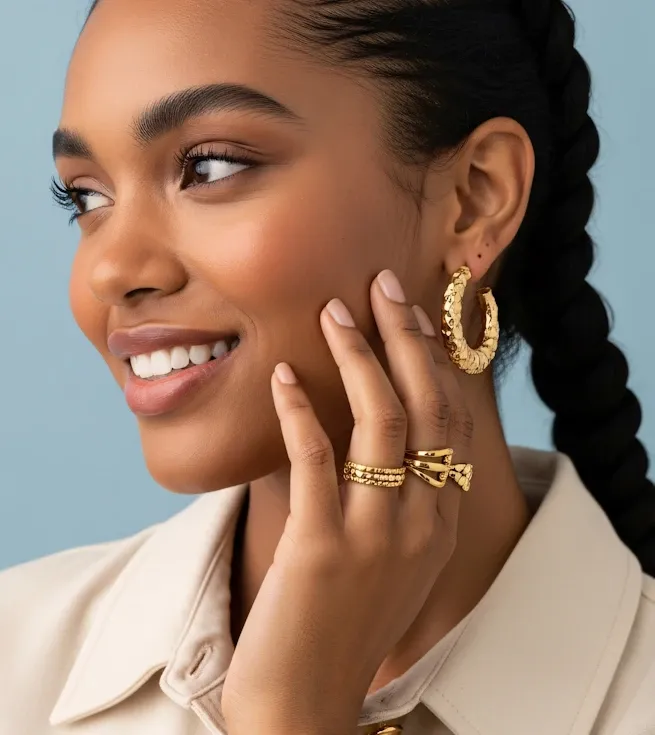 Sophia smiling, wearing sculpted gold hoops and stacked rings